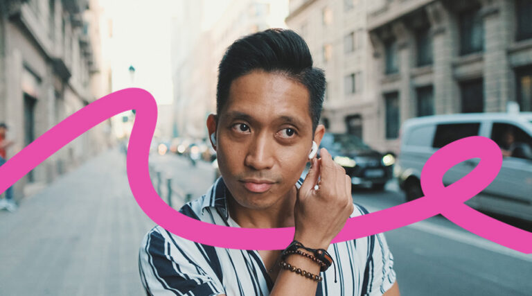 Portrait of a man on a city street wearing wireless earbuds and a striped shirt, with a pink abstract ribbon overlay across the image.